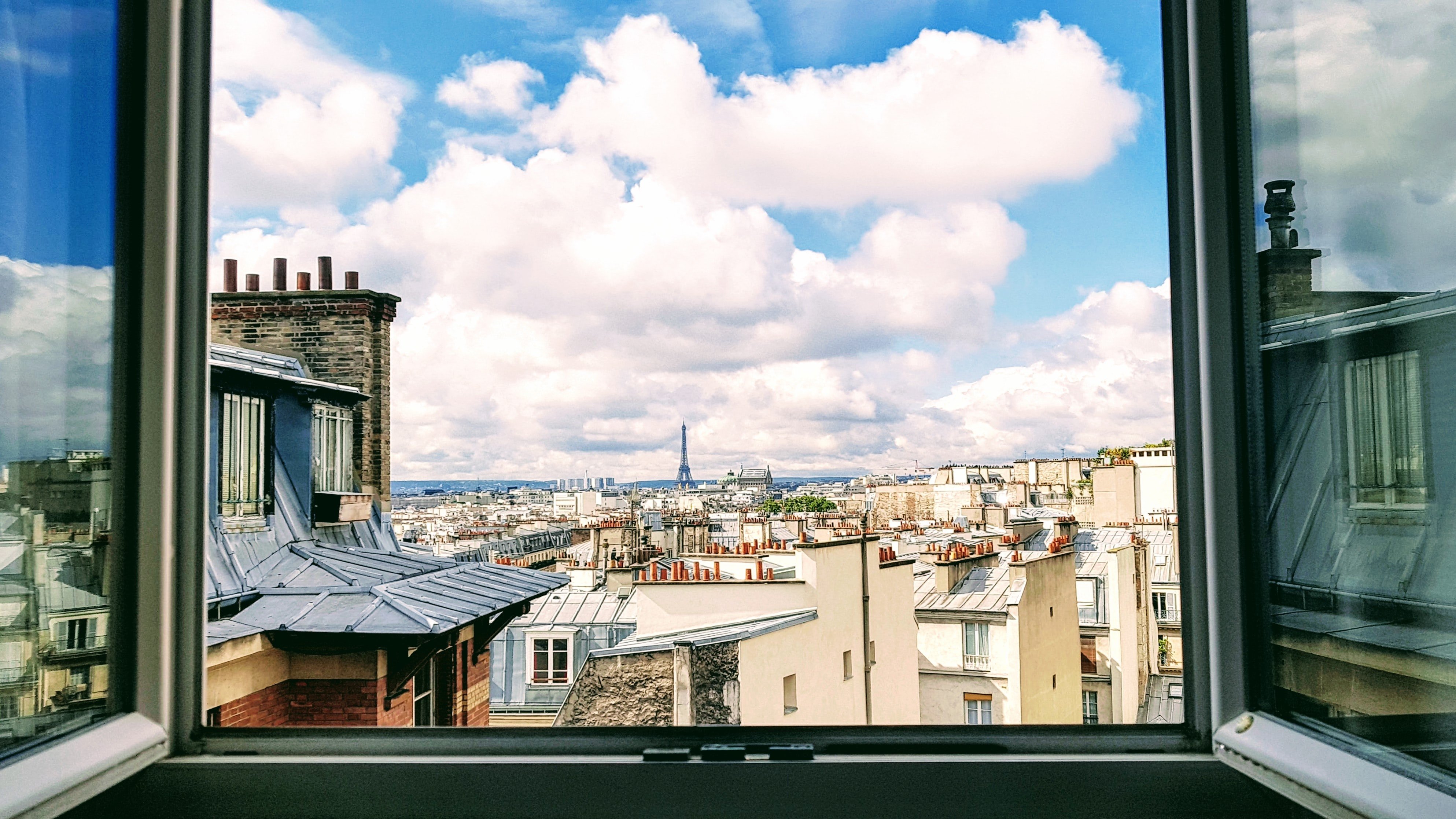 A view of Paris from an open window with the Eiffel Tower in the background