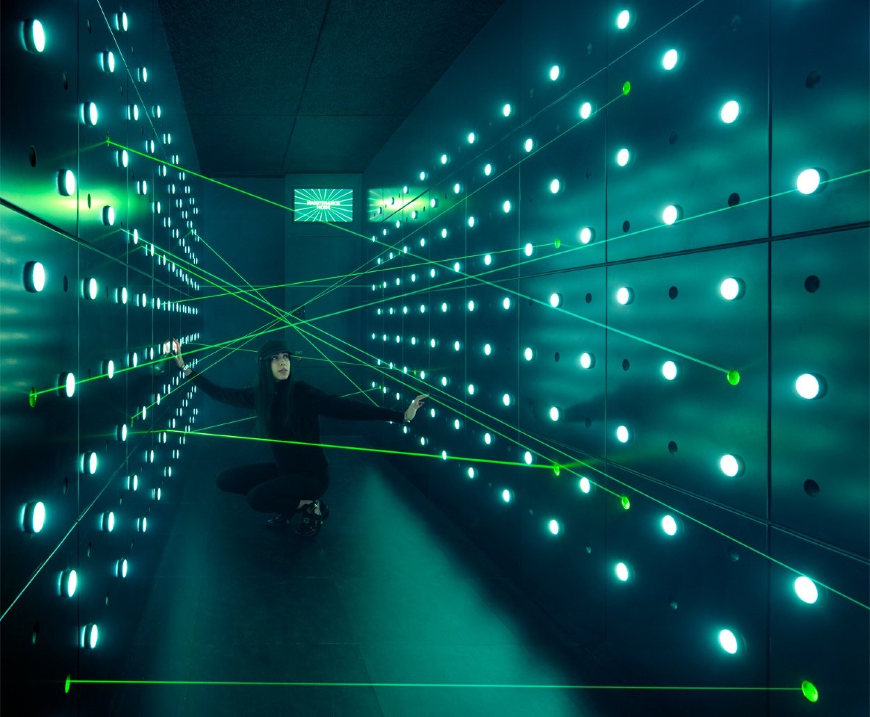 Woman kneeling down in laser beam challenge