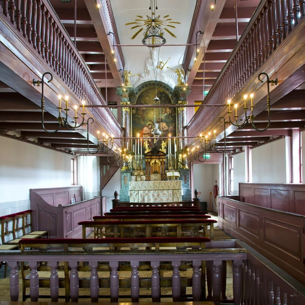 Old church interior with altarpiece in the centre.