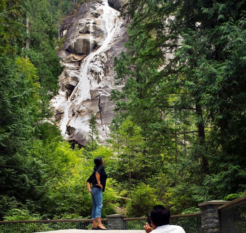 Woman looks up at Shannon Falls