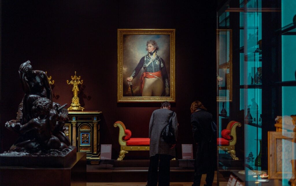 Visitors looking at art in a Met Museum gallery.