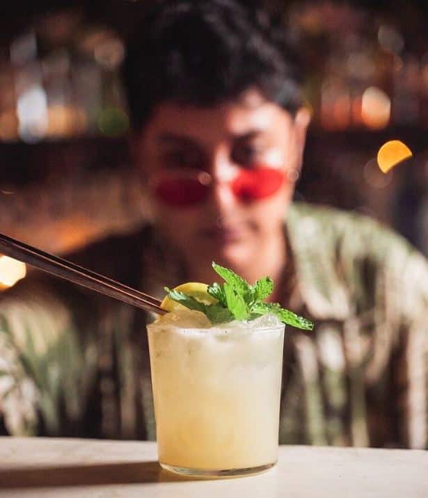 A woman with pink sunglasses enjoying a margarita
