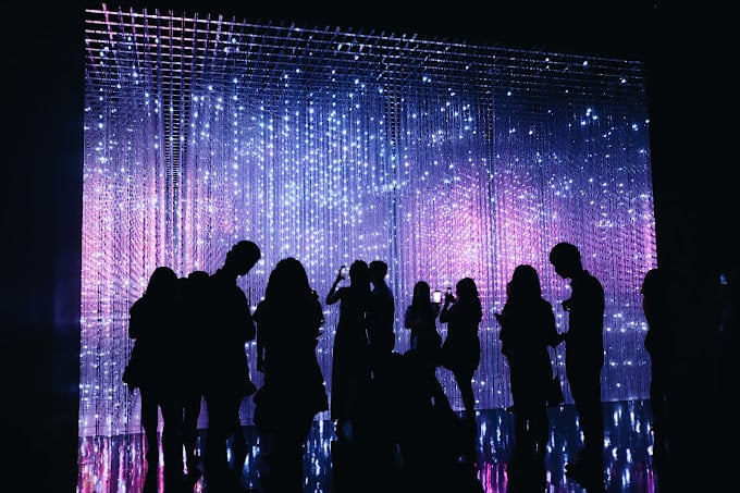 A crowd gathers at a light display inside the ArtScience Museum