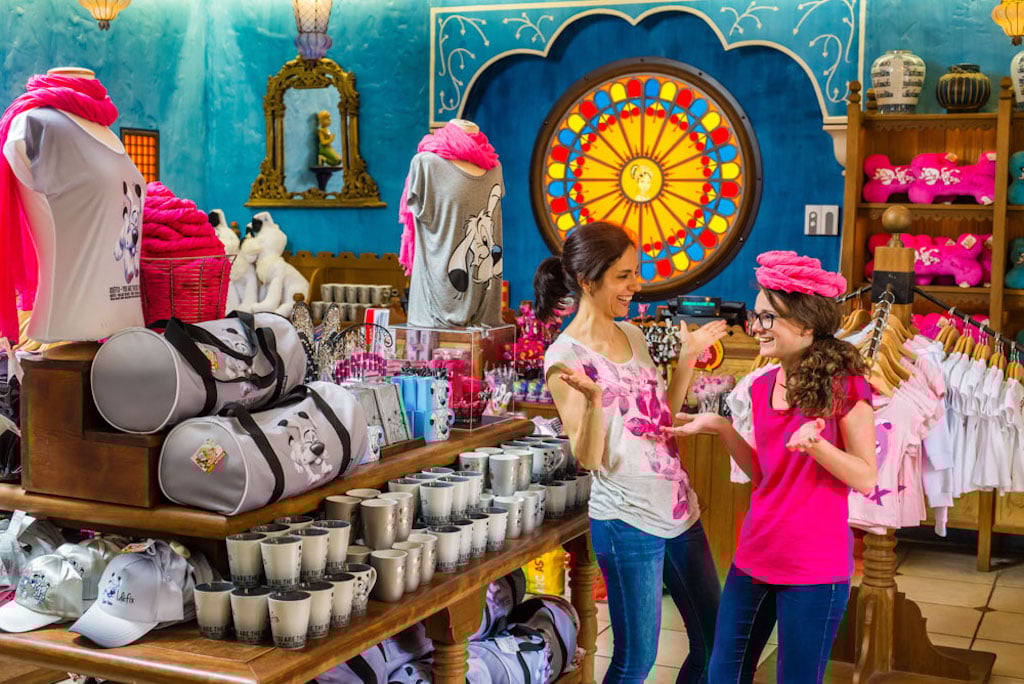 a woman in a white shirt with pink flowers and a girl in a pink shirt in a the souvenir store