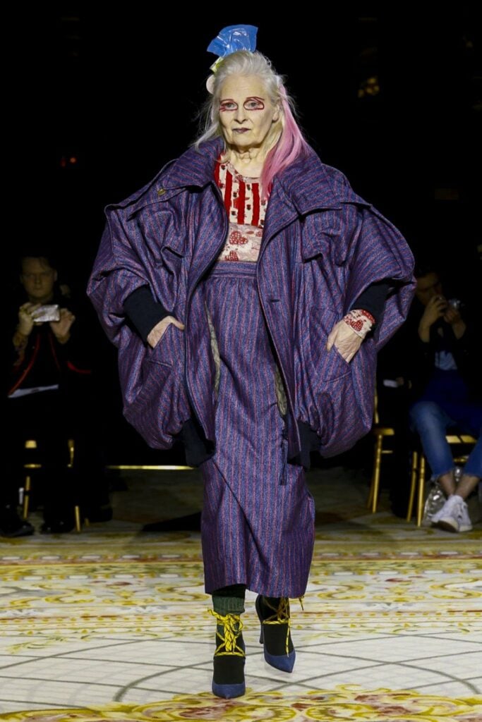 Fashion designer Vivienne Westwood struts down the runway in a blue pinstripe skirt and jacket as one of the most famous female artists.