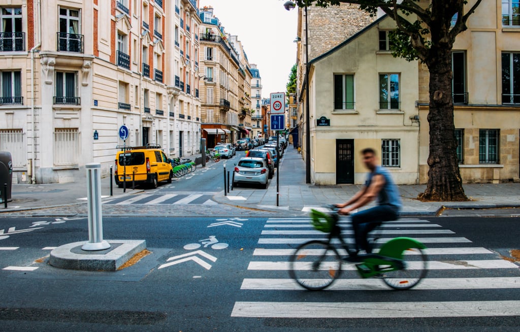A man cycling down the street in Paris