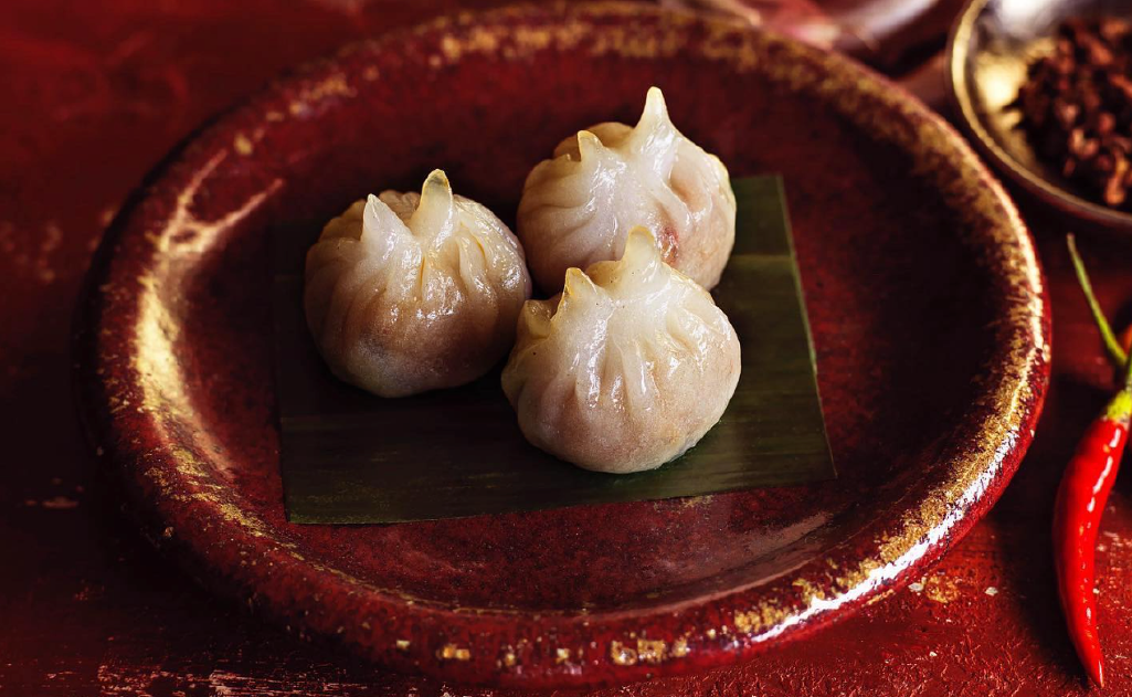 Three pieces of Dim Sum, plated on the red Chinese plate.