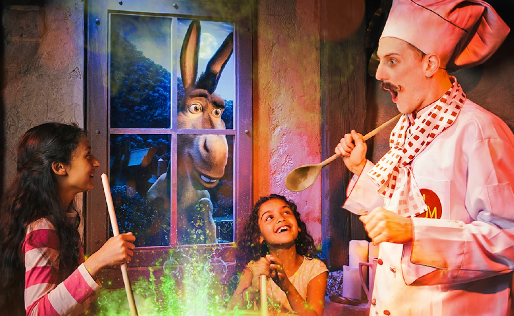 Kids enjoying Shrek's Adventure, cooking magic elixir in the pot.