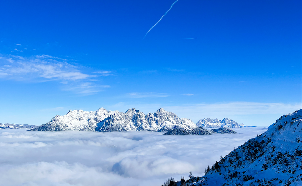 Photo of Austrian mountains view from above the clouds. 