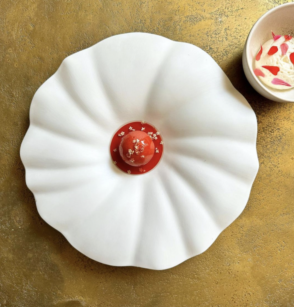 Beautifully served dessert on an elegant flowe-shaped plate.